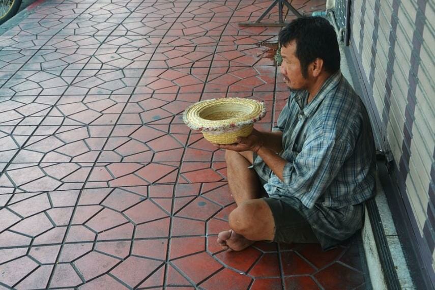 Beggar holding hat