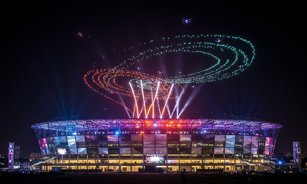 Drone light show over an illuminated stadium at night as a quieter alternative to fireworks